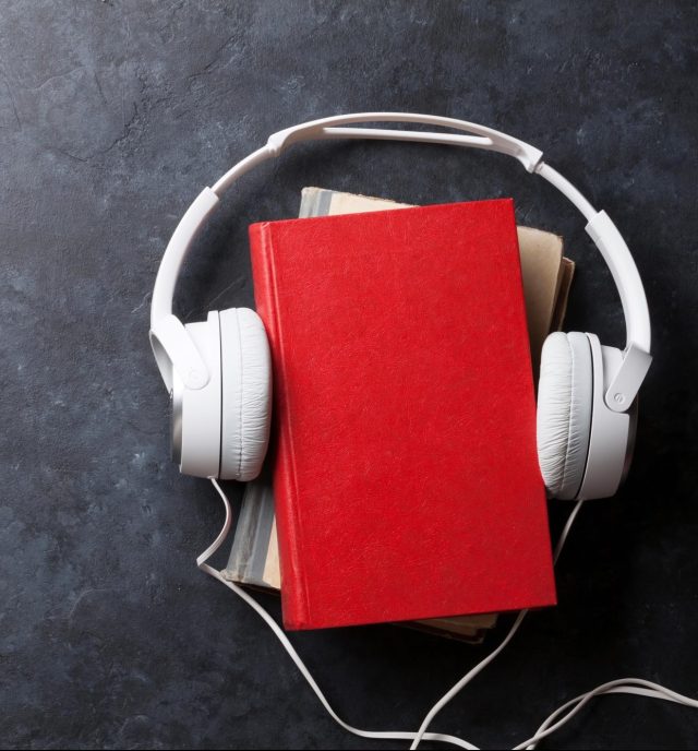 Audio book concept. Headphones and books over stone table. Top view with space for your text