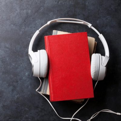 Audio book concept. Headphones and books over stone table. Top view with space for your text